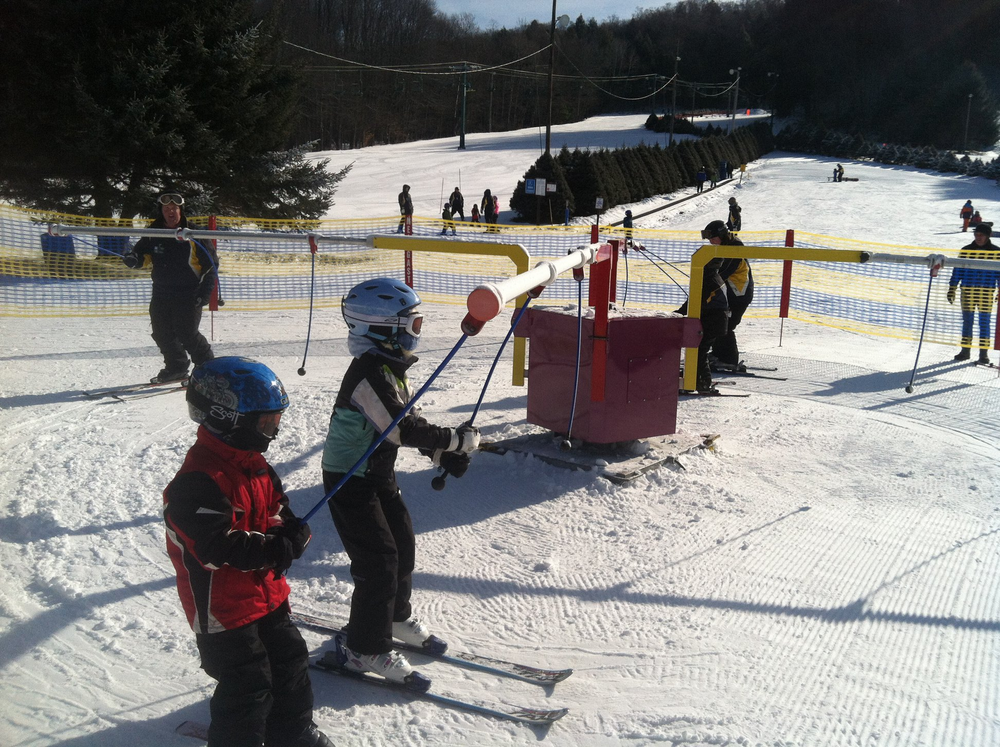 a group of people riding skis on top of a snow covered slope