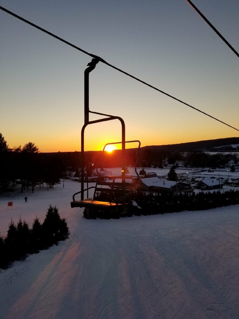 a traffic light with a sunset in the snow